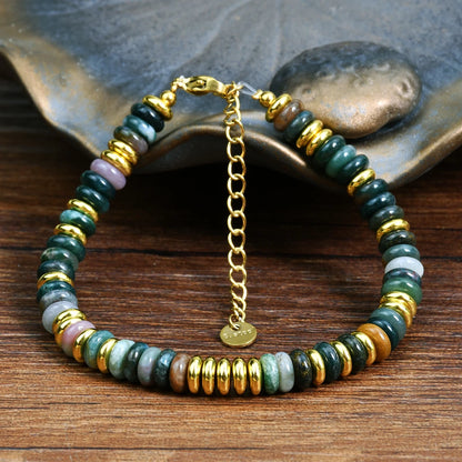 Beaded bracelet with gold chain on a wooden surface