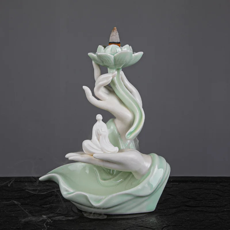 Decorative ceramic incense burner with lotus design on a dark surface and gray background