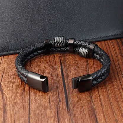 Black braided leather bracelet with metal clasp on a wooden surface