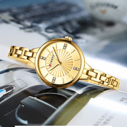Gold wristwatch with brand name on a car dashboard