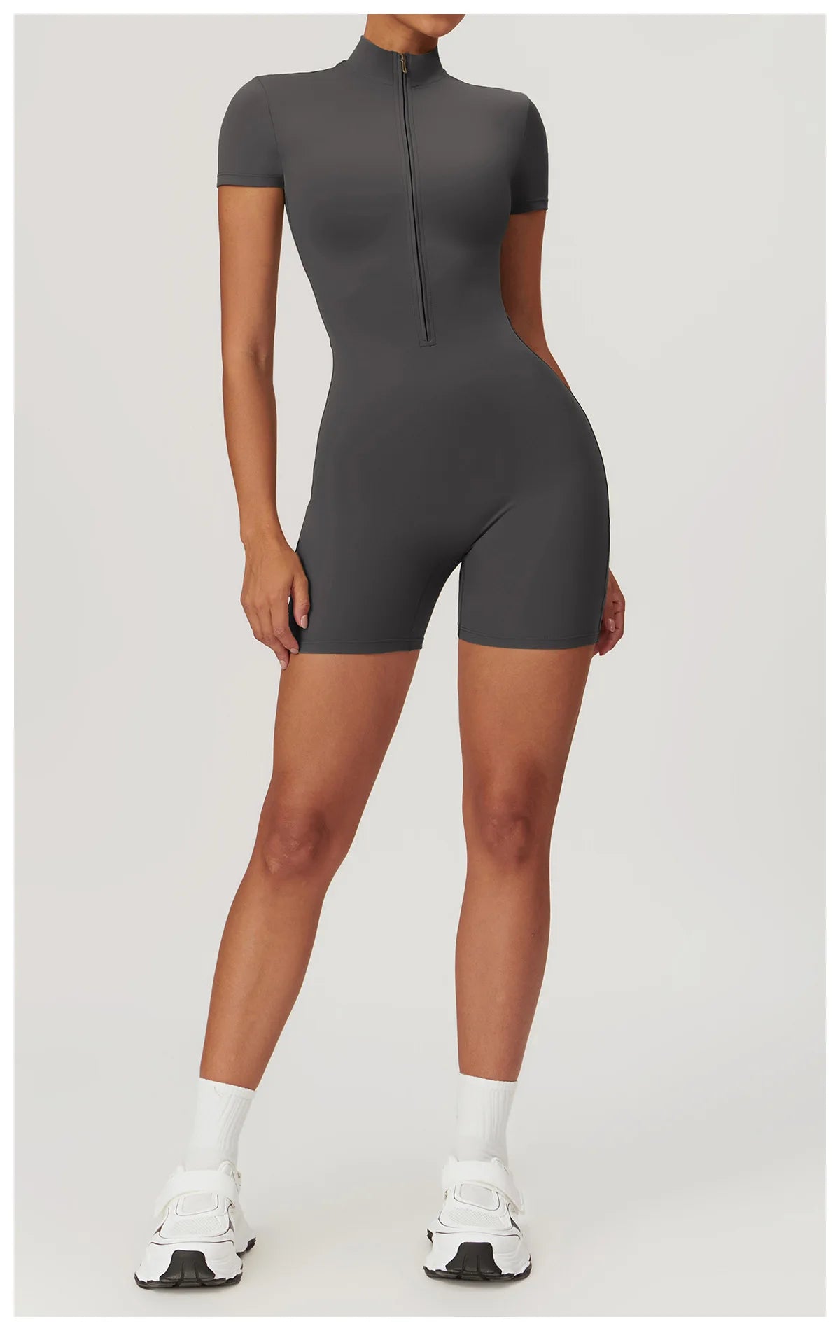 Person wearing a dark gray bodysuit on a white background