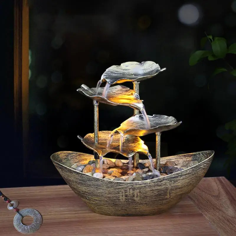 Decorative indoor water fountain with tiered bowls on a wooden surface