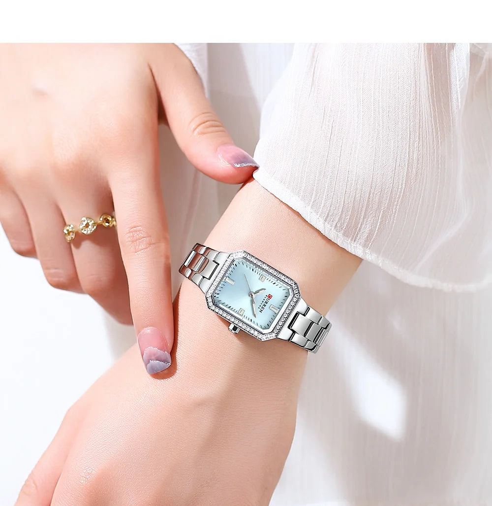 Silver wristwatch on a person's wrist with a white background