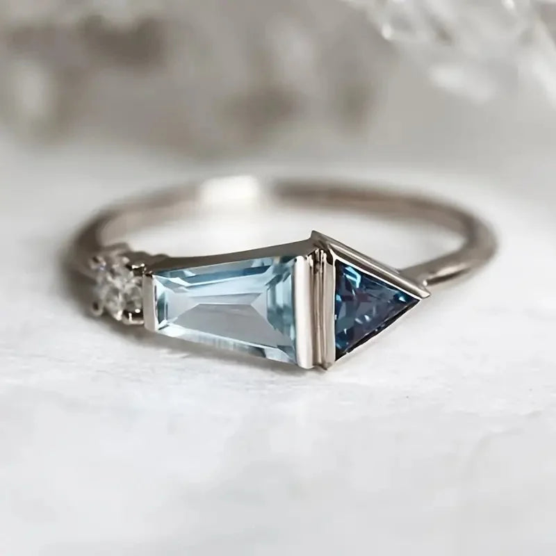 Silver ring with blue gemstone on a white background