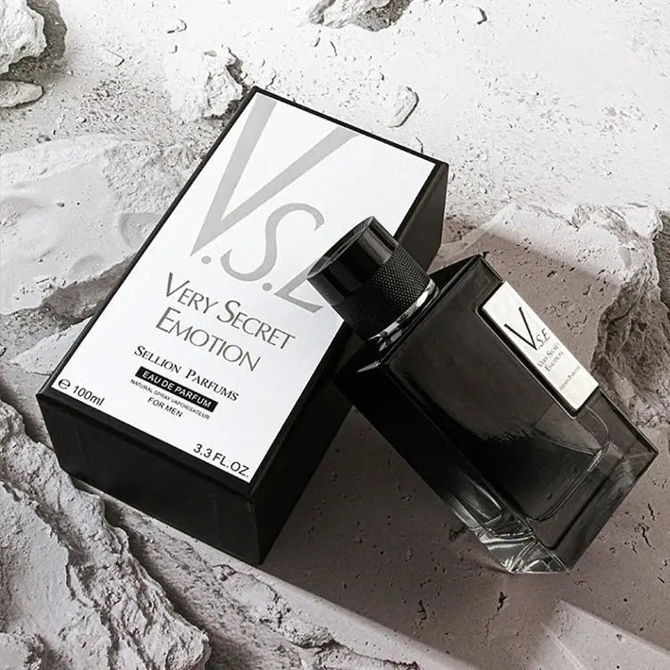 Black perfume bottle and packaging labeled 'Very Secret Emotion' on a textured surface.