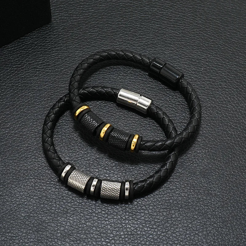 Black braided leather bracelet with metal clasps on a textured gray surface