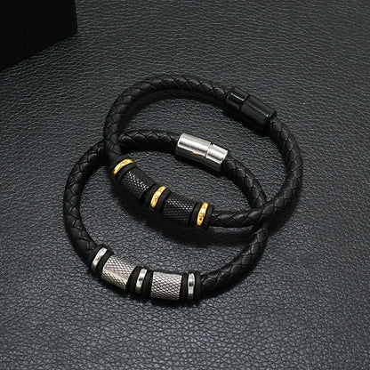 Black braided leather bracelet with metal clasps on a textured gray surface