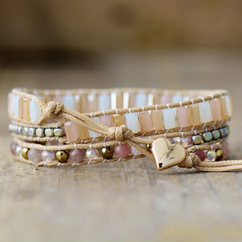 Multistrand beaded bracelet with heart charm on a wooden surface