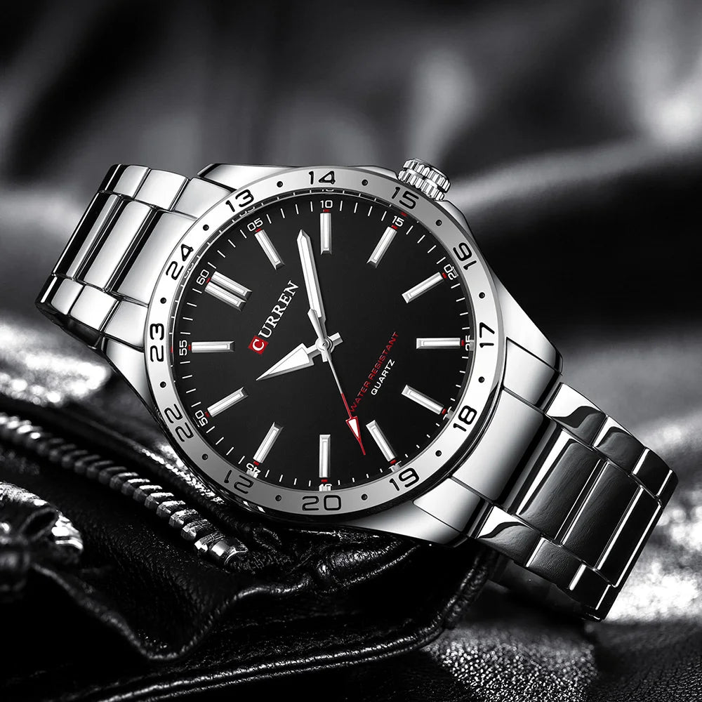 Silver watch with black dial on a textured surface