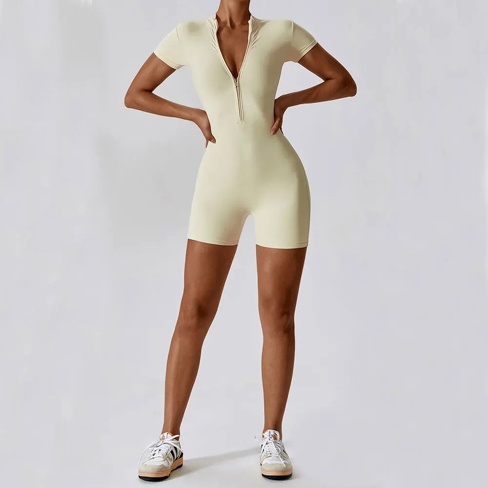 Person wearing a light yellow bodysuit on a plain background