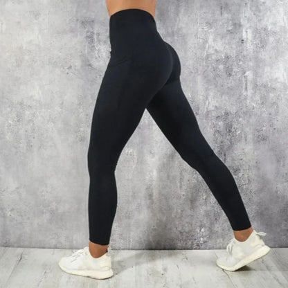 Person wearing black leggings against a gray concrete wall.