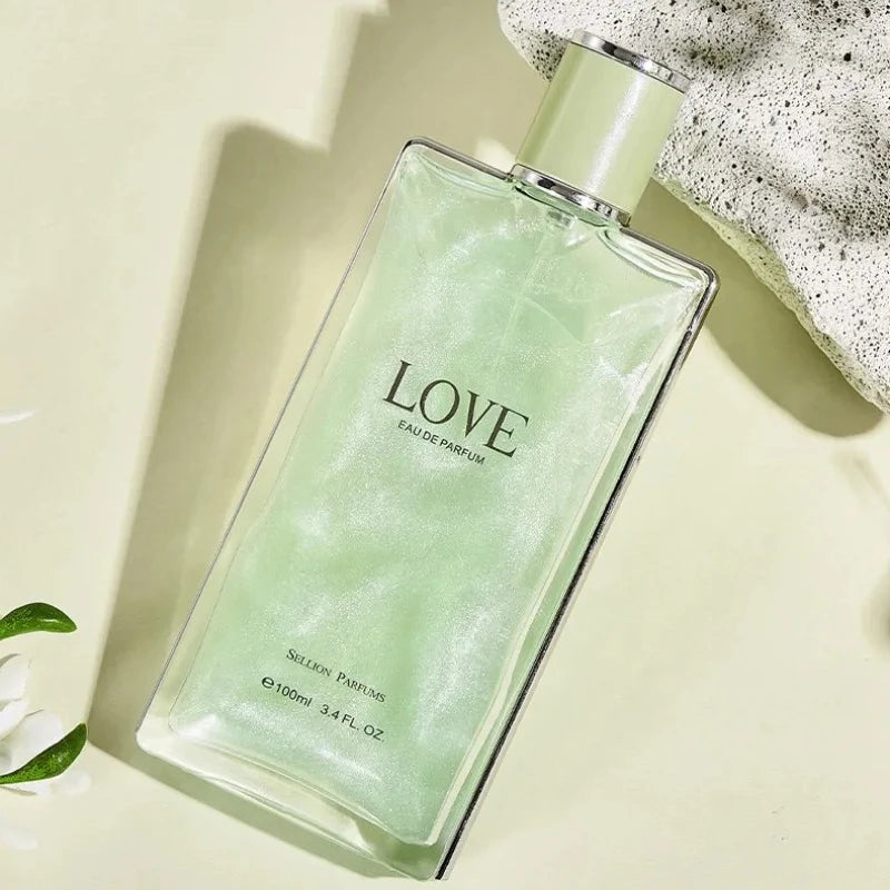 Green perfume bottle labeled 'LOVE' on a light background