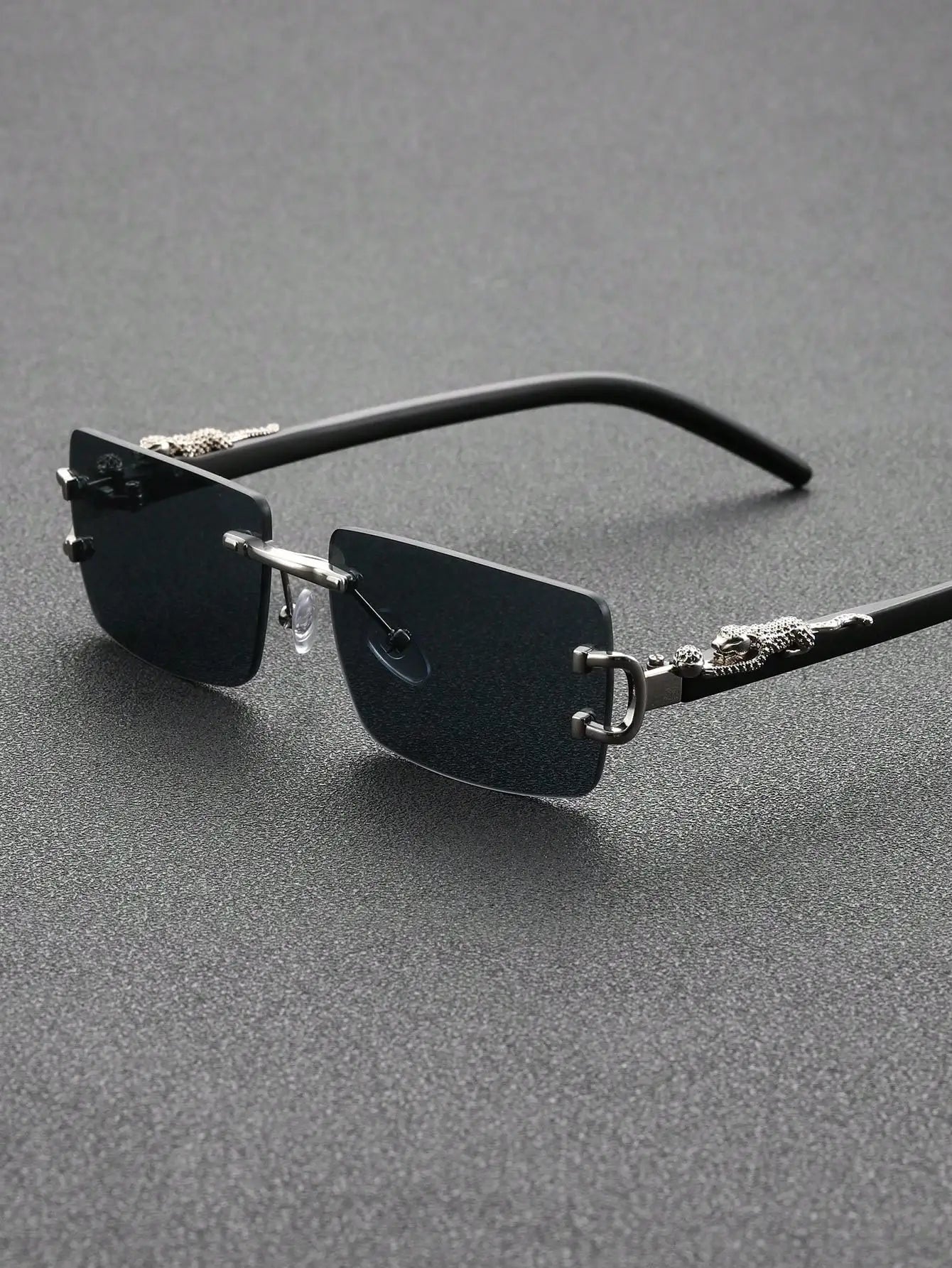 Sunglasses with metallic frame and dark lenses on a gray background