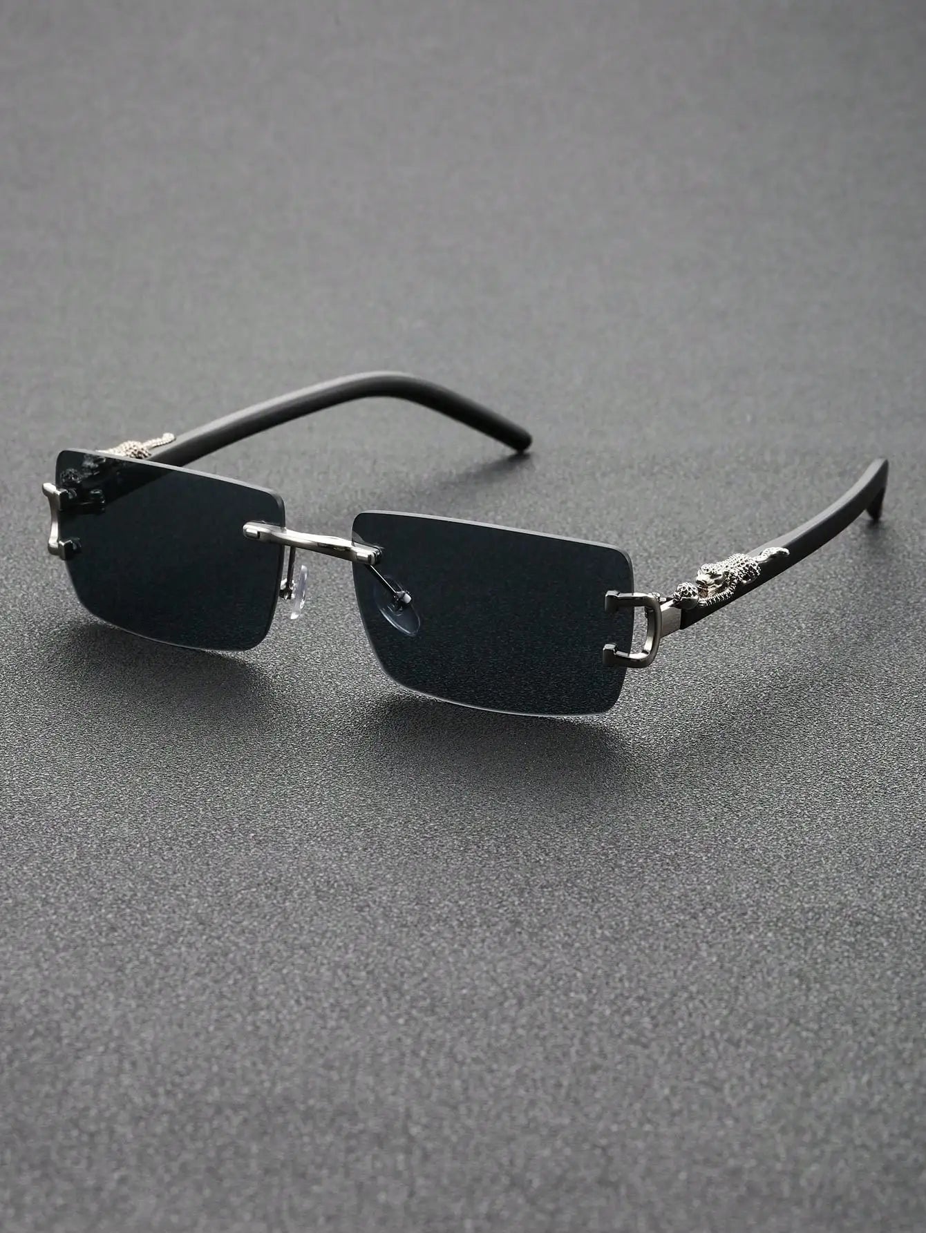 Sunglasses with thin frame and reflective lenses on a gray background
