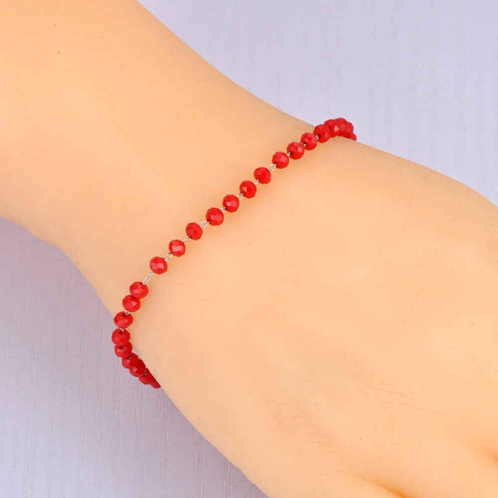 Red beaded bracelet on a person's wrist against a light background