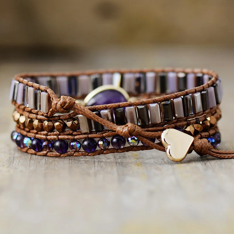 Multistrand bracelet with beads and heart charm on a wooden surface