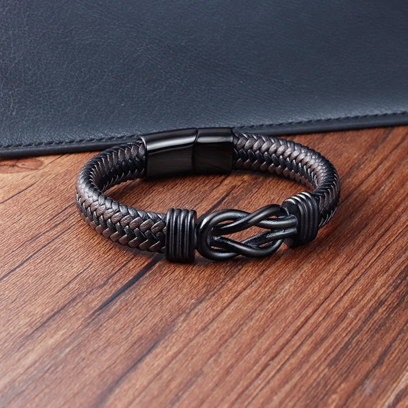 Black braided bracelet with a knot design on a wooden surface