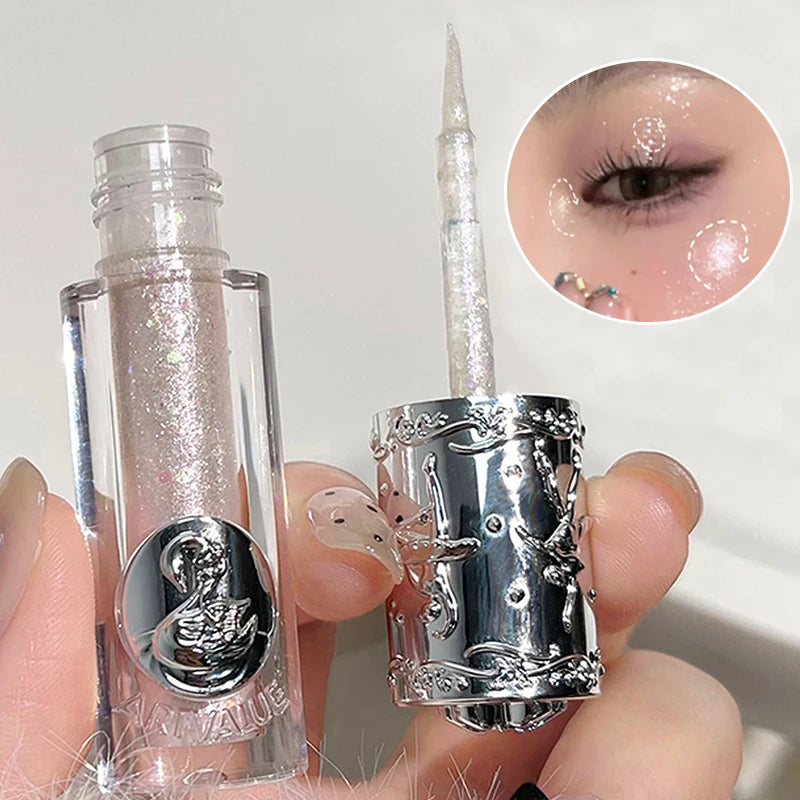 Silver eyeliner pen with decorative cap held by a hand, close-up of application on eyelid.