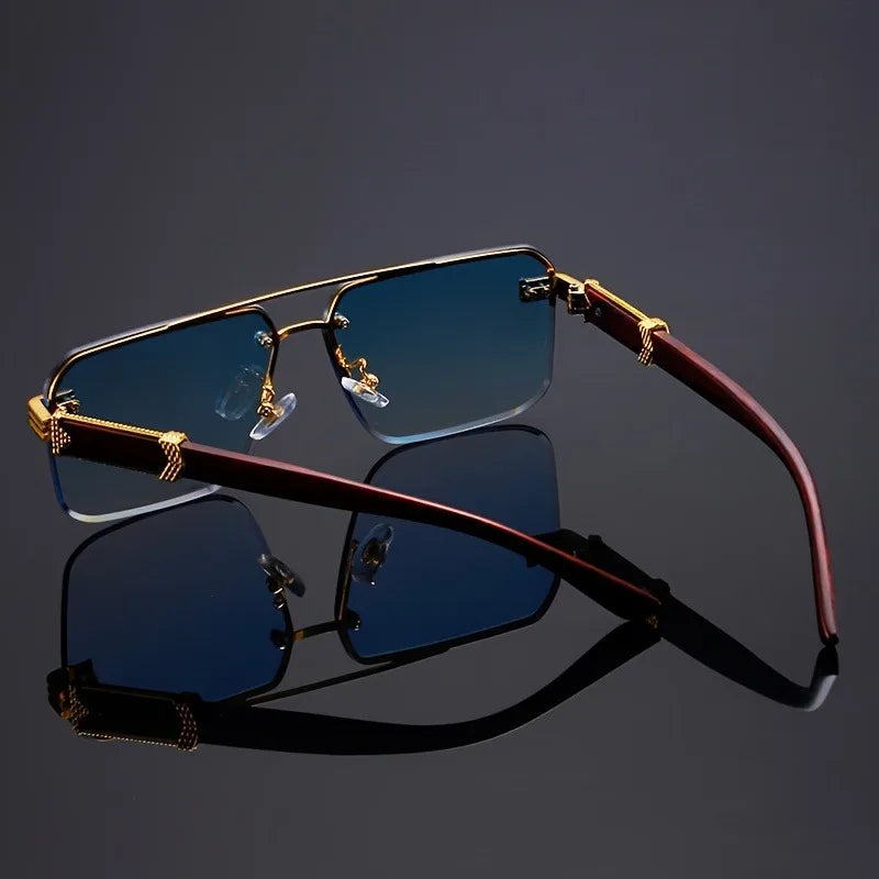 Sunglasses with gold frames and dark lenses on a reflective surface