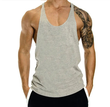 Person wearing a gray tank top with a tattooed arm on a white background