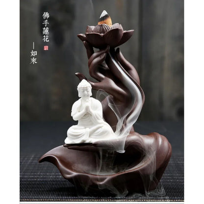 Decorative incense burner with a Buddha statue and lotus design on a dark background