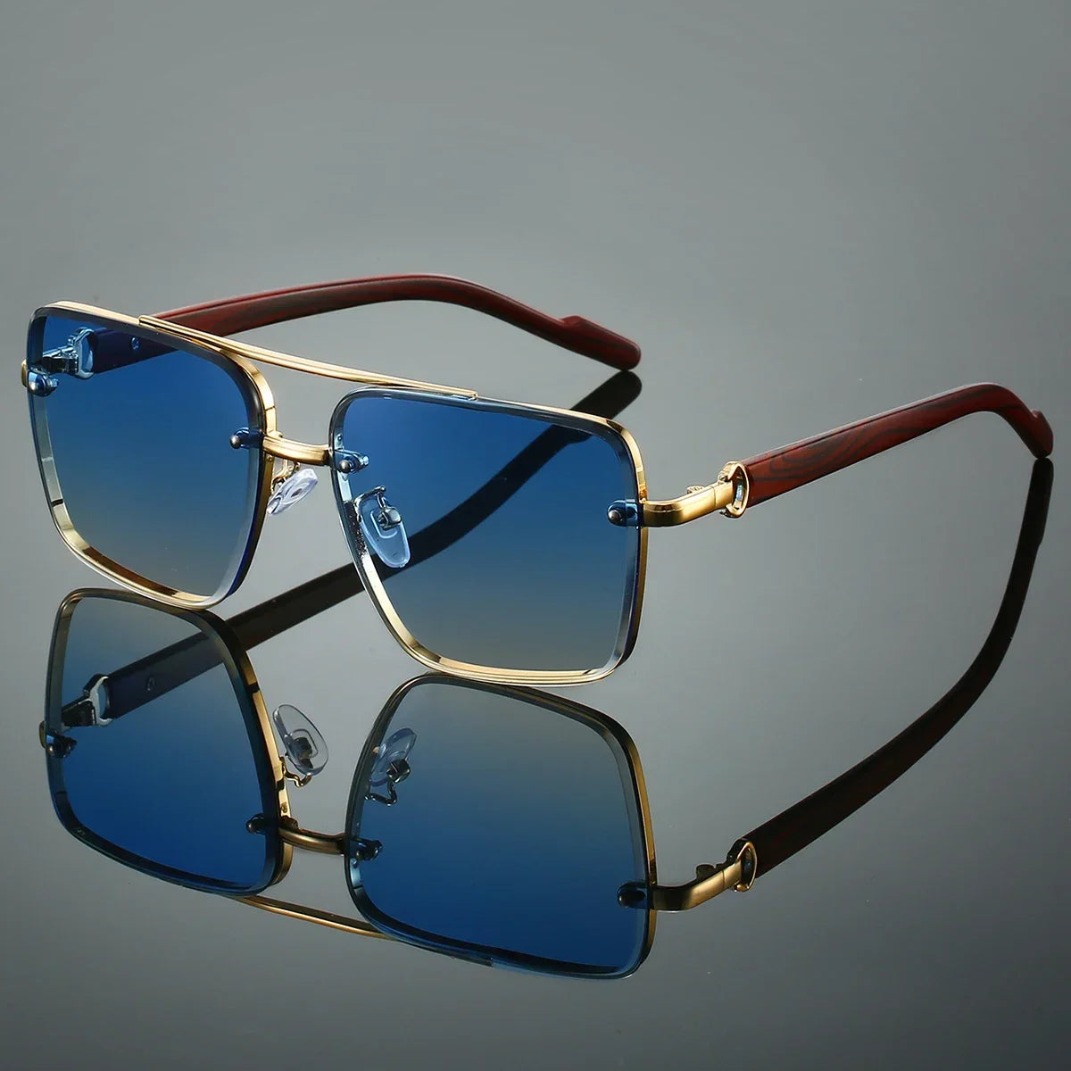 Sunglasses with gold frame and brown arm on a reflective gray surface
