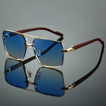 Sunglasses with gold frame and brown arm on a reflective gray surface