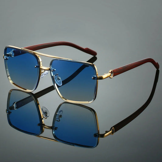 Sunglasses with gold frame and brown arm on a reflective gray surface