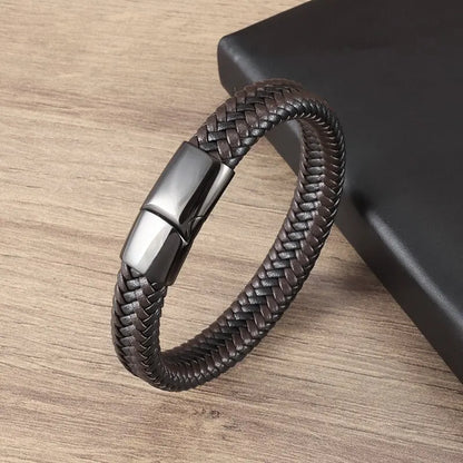 Brown braided leather bracelet with a silver clasp on a wooden surface