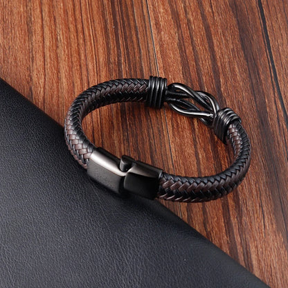 Black braided leather bracelet on a wooden surface