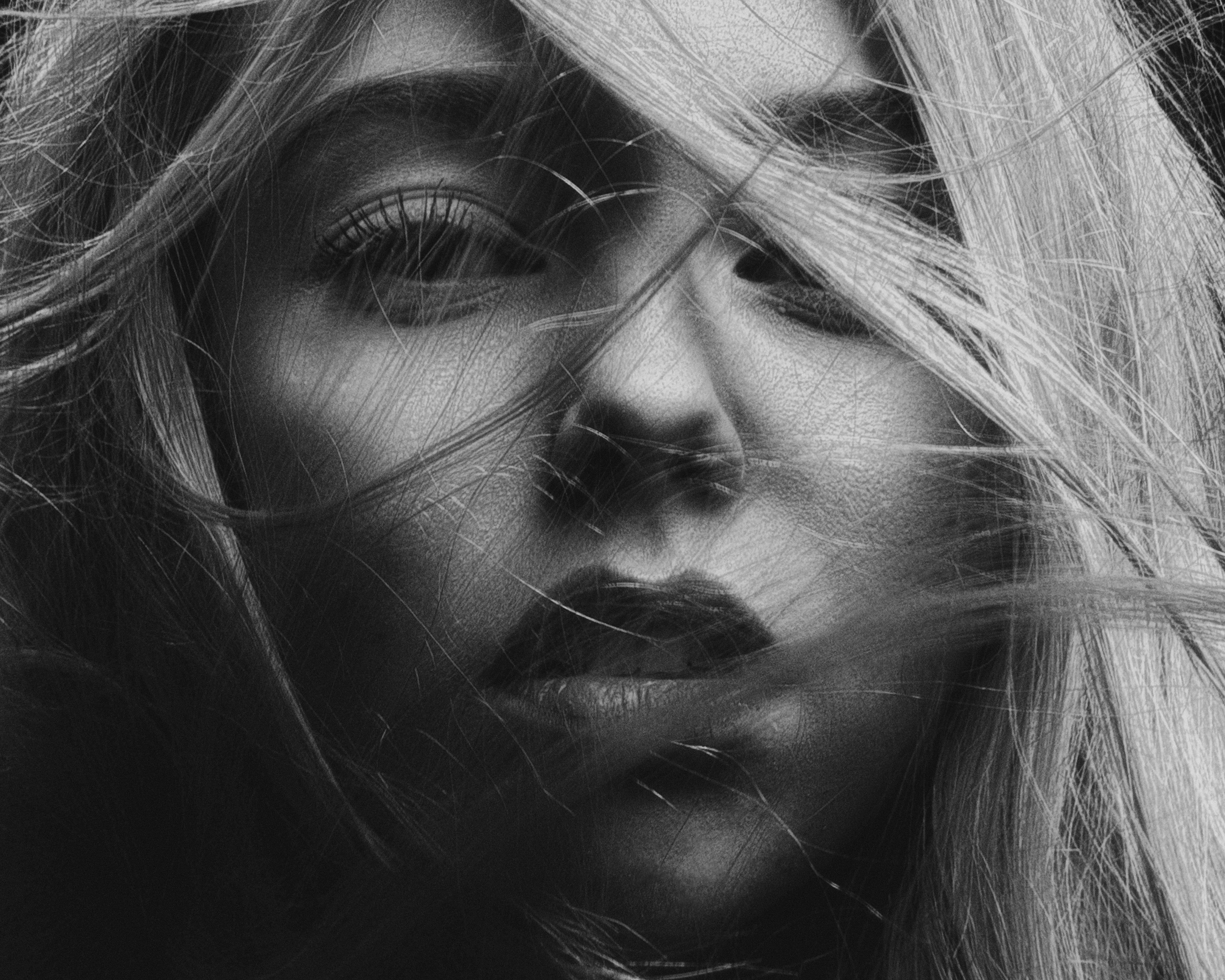 Black and white portrait of a woman with hair covering part of her face