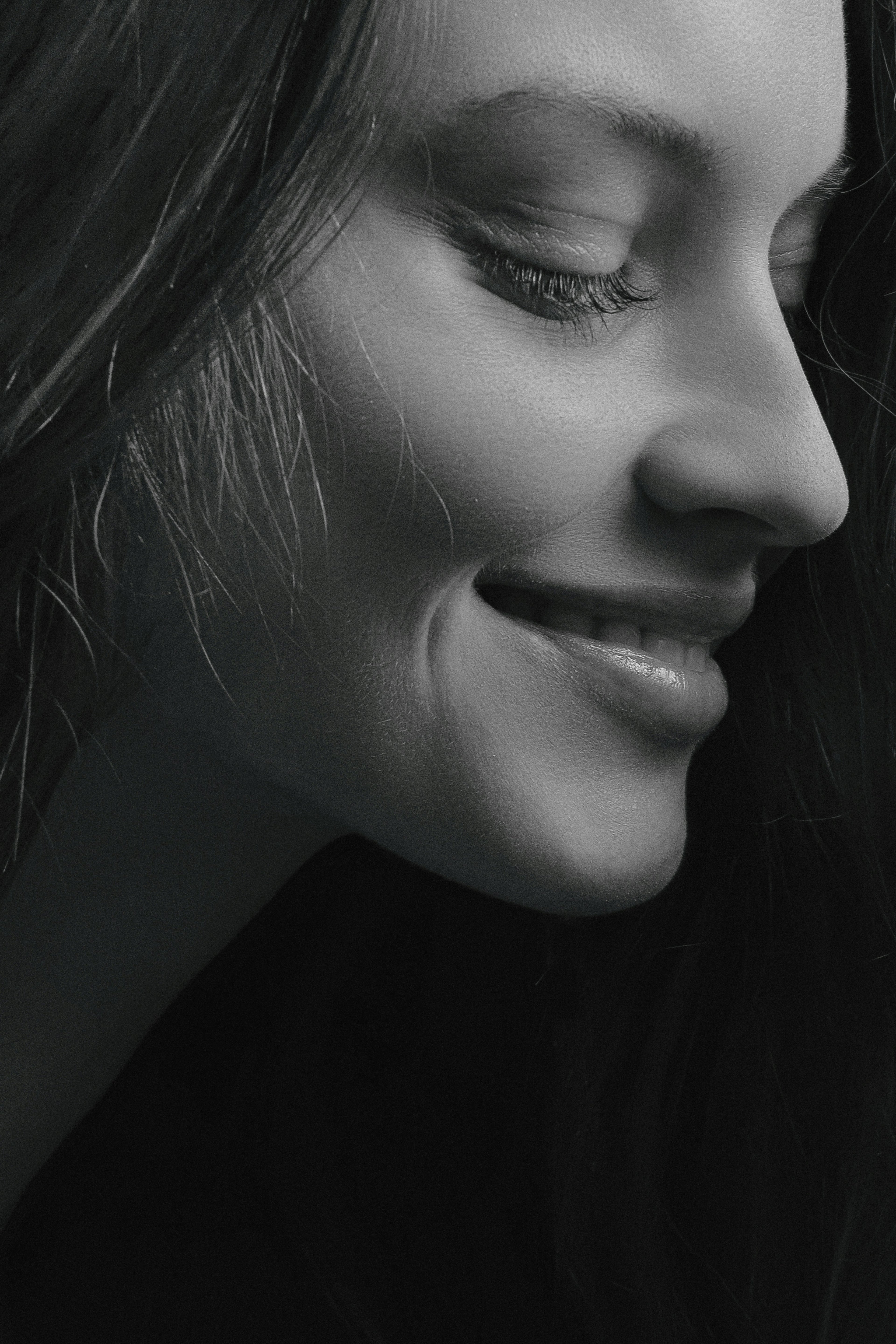 Black and white close-up of a woman's face with a soft smile.